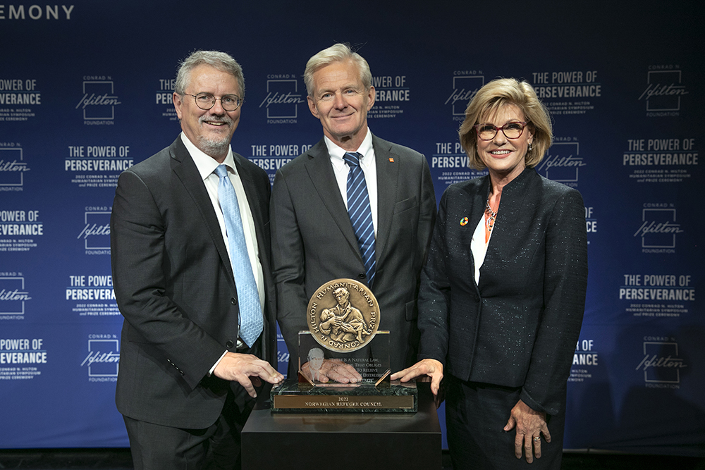 Peter Laugharn, left, president and CEO of the Conrad N. Hilton Foundation, and Linda Hilton, right, vice chair of the board of directors of the Hilton Foundation, present the 2022 Hilton Humanitarian Prize to Jan Egeland, secretary general of the Norwegian Refugee Council. (Courtesy of the Hilton Foundation)