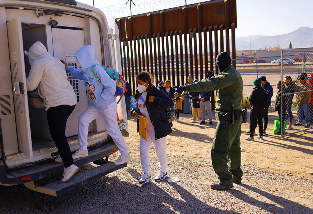 Migrantes detenidos por agentes de la Patrulla Fronteriza estadounidense tras cruzar a Estados Unidos desde México para solicitar asilo suben a un vehículo que los trasladará a un centro de detención el 19 de diciembre de 2022 en El Paso, Texas. (Foto: OSV News/Reuters/José Luis González)