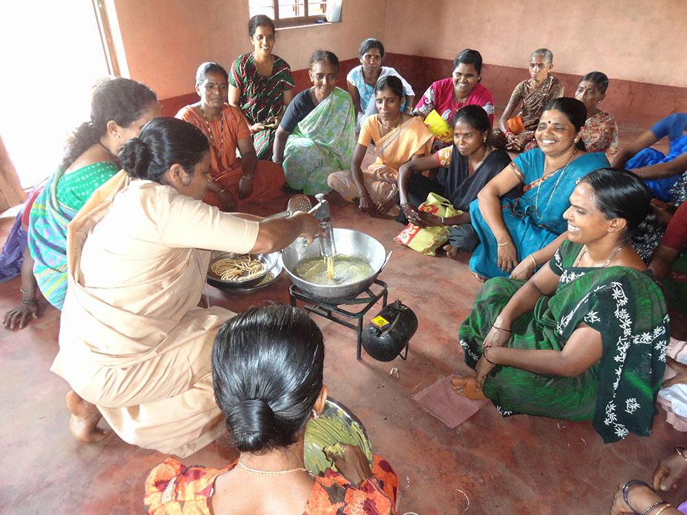 Helpers of Mount Rosary Sr. Roseline D'Souza demonstrates food preparation as part of promoting organic products for female entrepreneurs at a village center in the southwestern Indian state of Karnataka. (Courtesy of Celestine D'Souza)