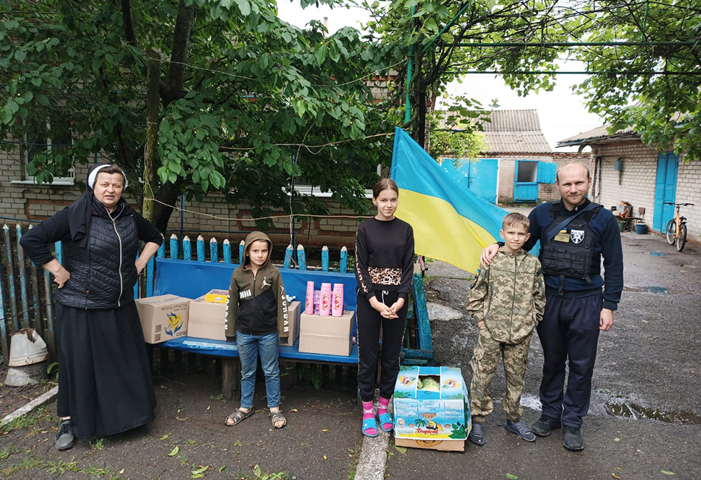 Sr. Lucia Murashko, left, is pictured with a family in the city of Zaporizhzhia, helping with efforts in responding to the floods caused by the June 6 collapse of the Nova Kakhovka dam on Ukraine's Dnipro River. (Courtesy of Sr. Lucia Murashko)