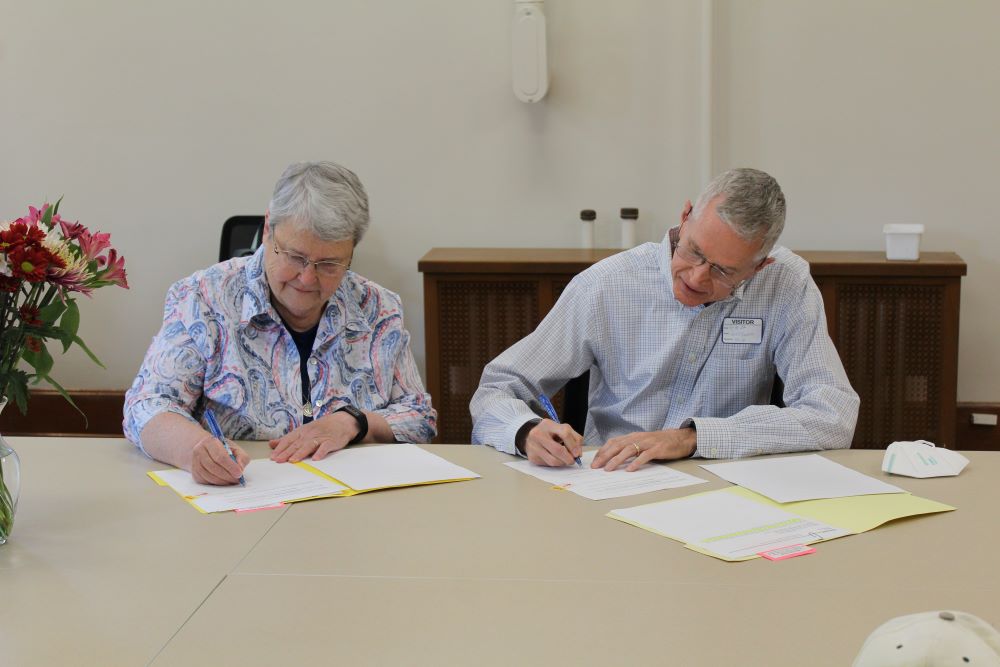 Sr. Patricia Hayden, Sisters of Charity president (left), and Jeff Ginter, president of the Western Wildlife Corridor Board of Trustees, sign the official paperwork to transfer 73 acres of property from the Sisters of Charity of Cincinnati to the Western Wildlife Corridor, Inc. 