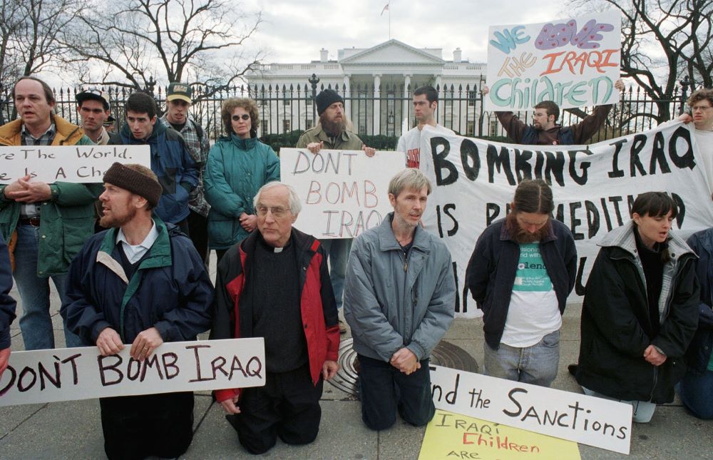 Detroit Auxiliary Bishop Thomas Gumbleton kneels with other demonstrators in front of the White House Feb. 12, 1998, to protest military strikes against Iraq. 