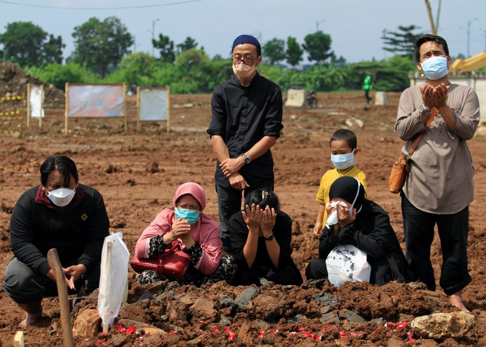 Relatives of a 31-year-old man who died after contracting COVID-19 pray after his funeral June 21 at a cemetery provided by the government for victims of the virus in Jakarta, Indonesia. (CNS/Reuters/Ajeng Dinar Ulfiana)