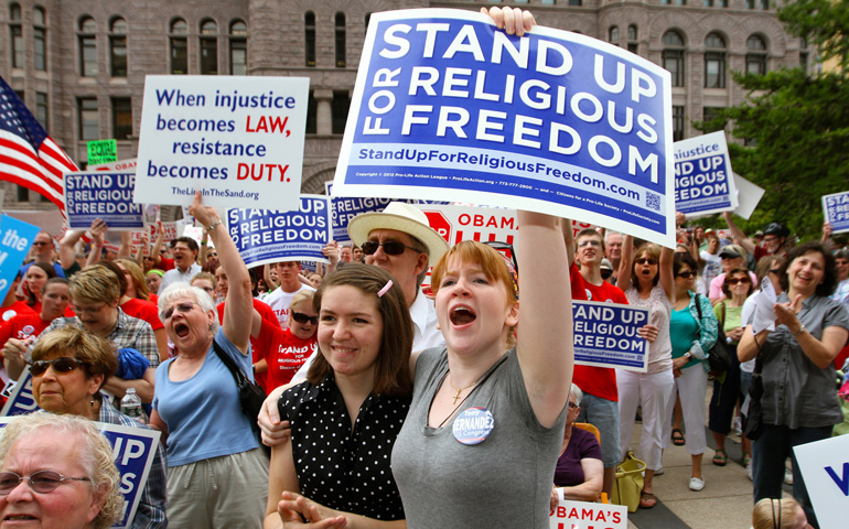 Catholics Caitlin Heaney, right, and her sister, Elizabeth, show their support during a rally for religious freedom June 8 in downtown Minneapolis. (CNS/The Catholic Spirit/Dave Hrbacek)