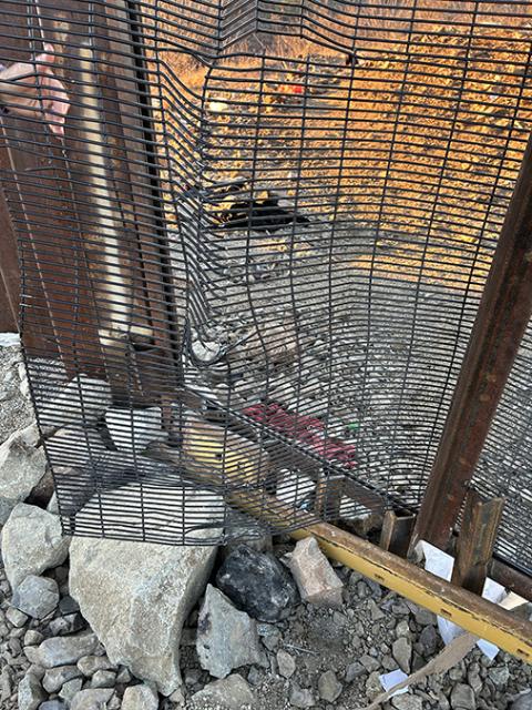 Asylum-seekers crawled through this small, twisted opening in a steel grate fence of the U.S.-Mexico border wall. (Peter Tran)