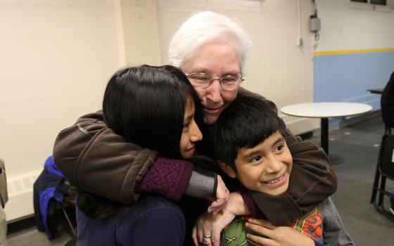 Sr. Margaret Smyth hugs two children