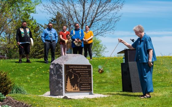 Sr. Ann Rehrauer, community president of the Sisters of St. Francis of the Holy Cross in Green Bay, Wisconsin, uses a censer May 14 to bless a monument with a plaque that acknowledges "the First Nations people who are the original inhabitants of this regi