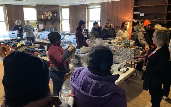 Migrants select clothing and blankets at the Migrant Ministry by the Catholic parishes of Oak Park, a suburb of Chicago. (Sue Paweski)