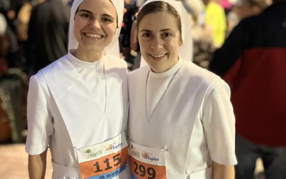 Srs. Juliana Alfonso and Nicole Daly share a smile before starting their 13.1-mile half marathon in Naples, Florida, Jan. 14, wearing full habits.