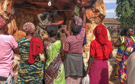 Women pilgrims raise their hands in prayer before a statue depicting the execution of one of the Uganda martyrs. Located at Namugongo, the site is a major center of Christian faith and reflection, especially during the June 3 annual feast day celebrations. (GSR photo/Gerald Matembu)