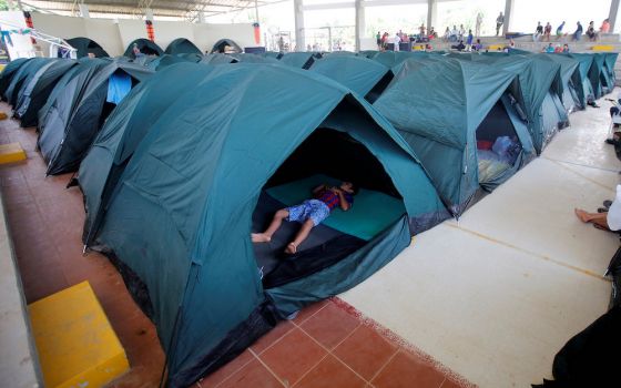 A child sleeps in a tent April 4, 2017, at a shelter for people left homeless after mudslides in Mocoa, Colombia. (CNS/Reuters/Jaime Saldarriaga)