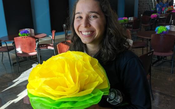 Sister Miriam poses with a Mexican paper flower at the Hope Border Institute's October teach-in she hosted. (Samantha Kominiarek)