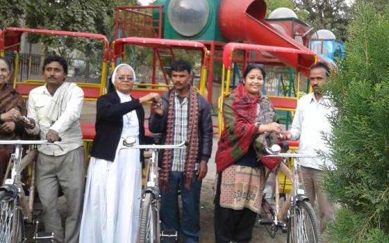Sr. Celine Arikkat, a member of the Franciscan Clarist Congregation, hands over a rickshaw to a migrant earlier this year. Arikkat has organized three-wheel-cycle-cab drivers in Noida, a satellite town of New Delhi. (Rita Joseph)