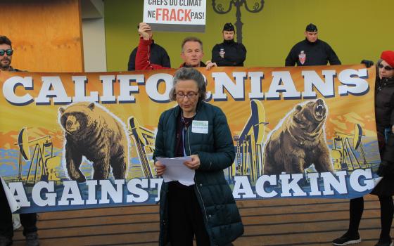 Mercy Sr. Aine O'Connor speaks at an anti-fracking rally outside the main venue of COP21 in France. (NCR photo/Brian Roewe)