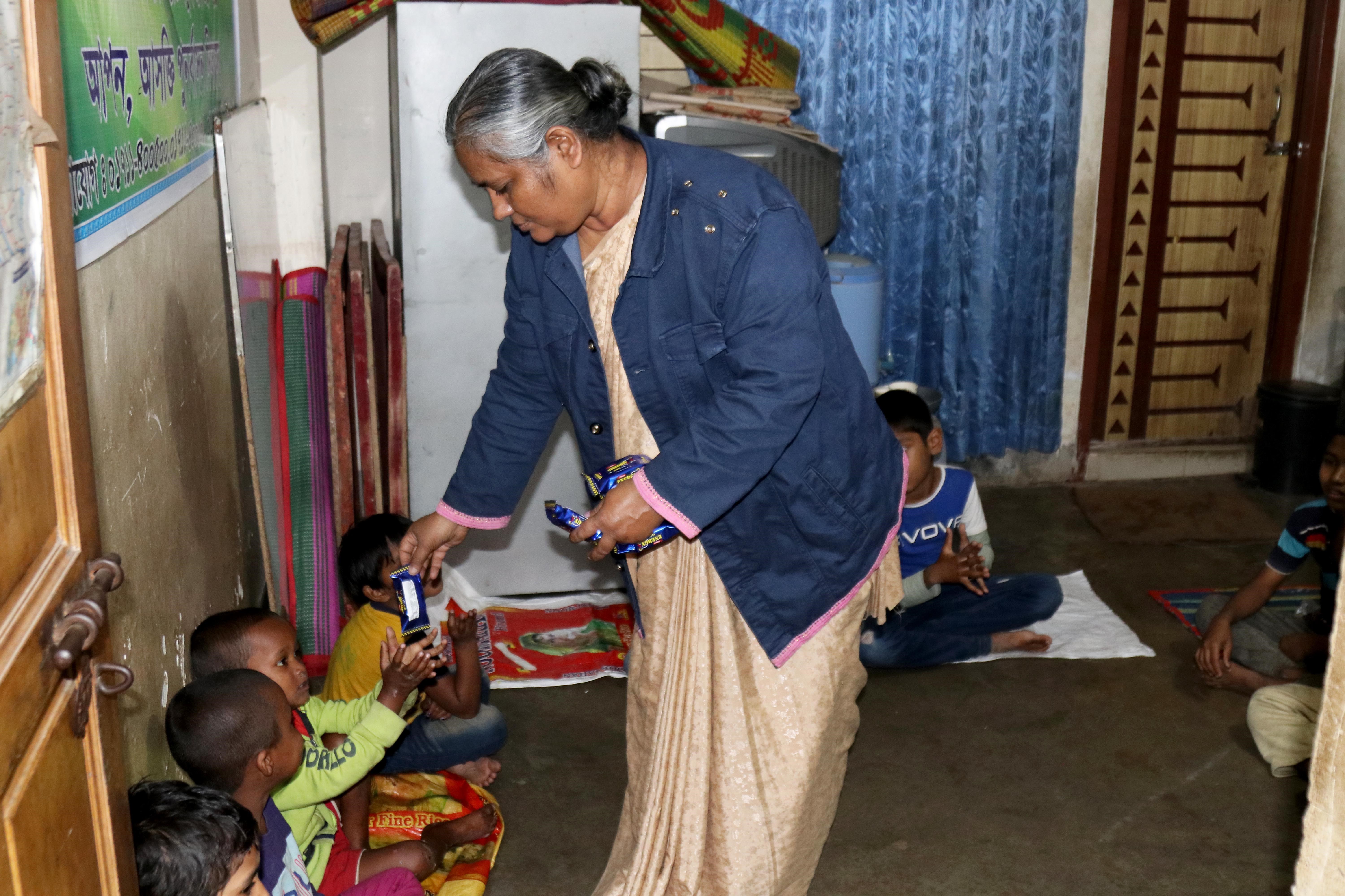 Sr. Monju Maria Corraya distributes biscuits to each child every day at the center. 