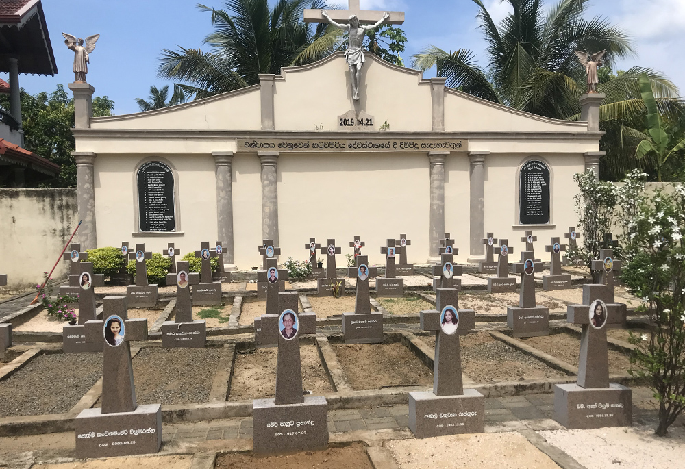 A mass graveyard on St. Sebastian's Church, Katuwapitiya, Sri Lanka, with photos displayed on the crosses of the victims of the 2019 Easter bombing (Thomas Scaria)