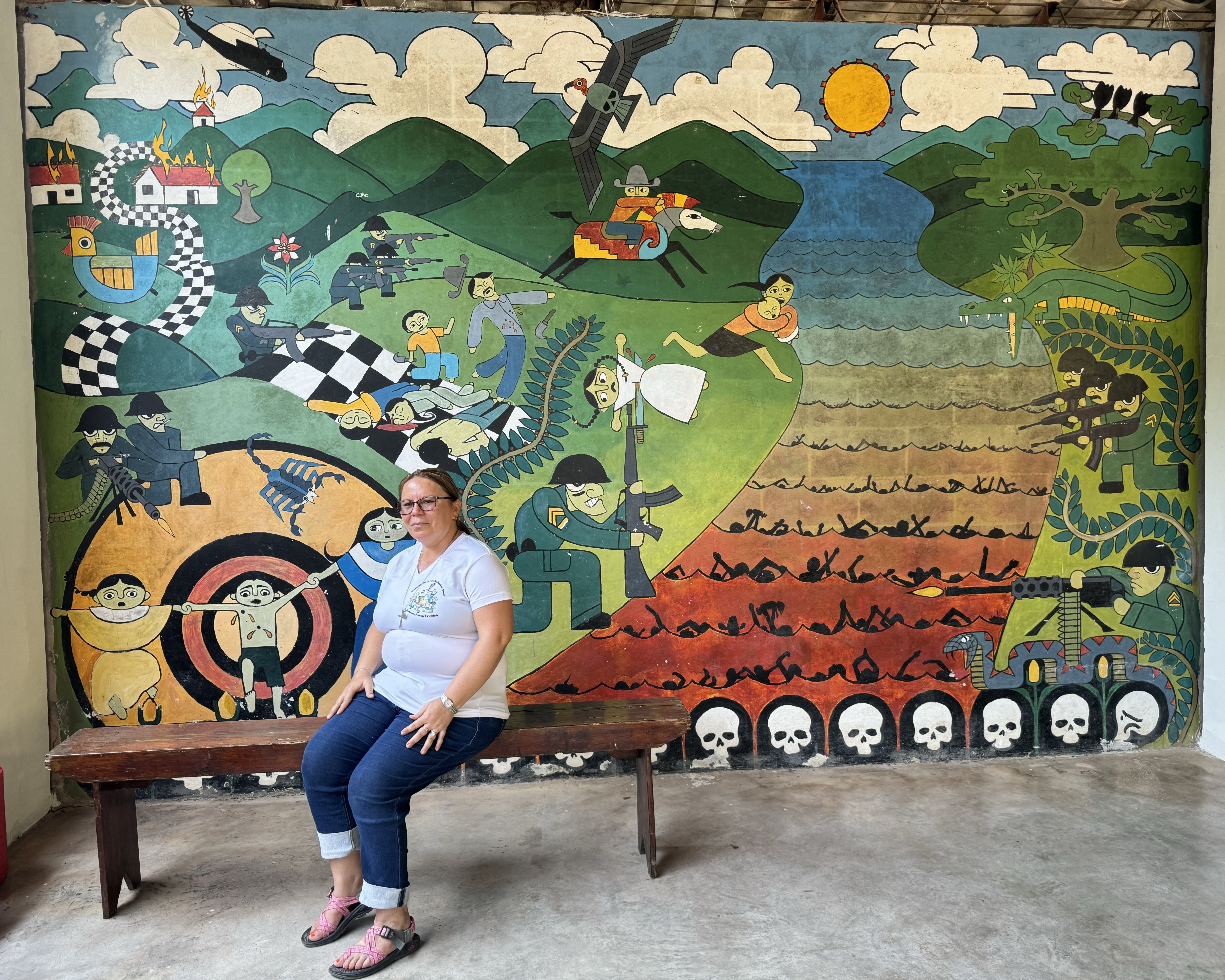 Providence Sr. Vilma Franco sits on a bench in her hometown of Arcatao, El Salvador, April 27, in front of a mural depicting the 1980 massacre on the Sumpul River. Each year, organizations like the Sumpul Association remember the massacre of more than 600 people by armed forces, with a pilgrimage and Mass, an effort to educate and prevent future atrocities. (GSR photo/Rhina Guidos)