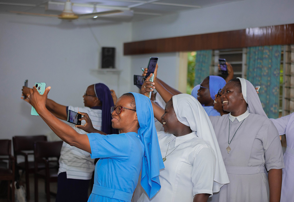 Sister communicators from Ghana practice at a training session at the Centre for Spiritual Renewal May 8 at Santasi, Kumasi, on how to use a cellphone to take better photos. (Newswatchgh.com/Damian Avevor)