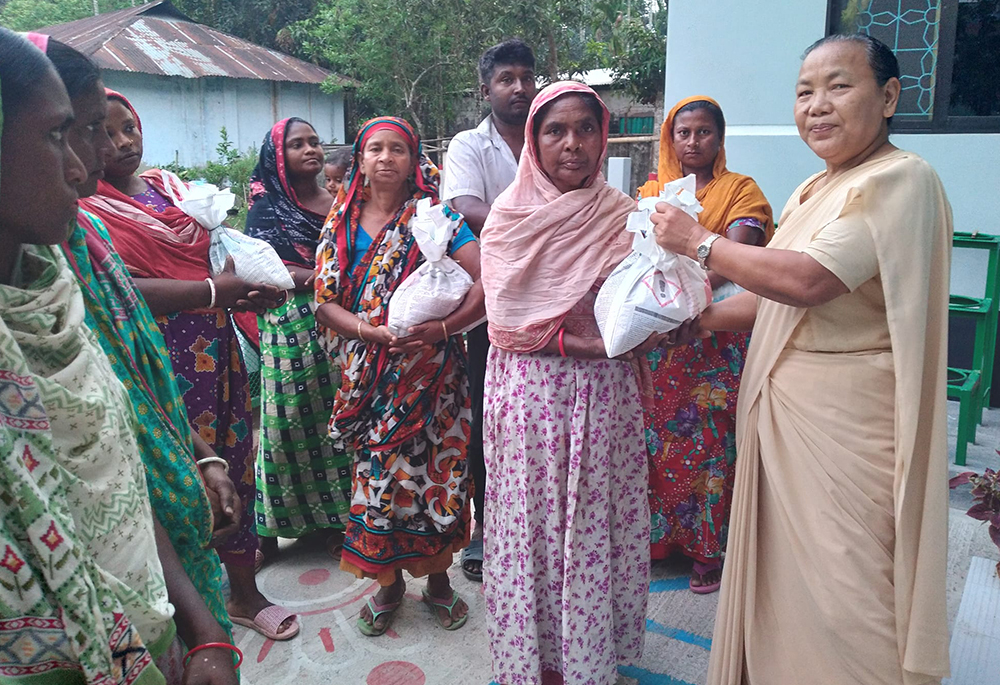 Sr. Minita Chisim hands out food to residents of the Bangladeshi village of Mariapolli, who lost their homes, food and clothes in a storm April 9. Amid a cyclone May 26-27, the Congregation of Our Lady of the Missions Sisters also arranged shelter and provided food in their school for people in the southern village of Bagerhat. (Courtesy of Sr. Sukriti B. Gregory)