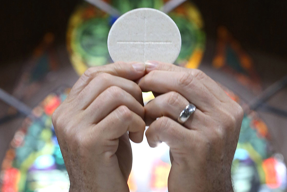 A priest raises the Eucharist in this illustration. (OSV News/CNS file/Bob Roller)