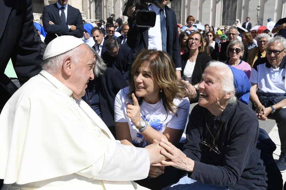 Pope Francis, seated, shakes hands Sister Genevieve, also seated. 