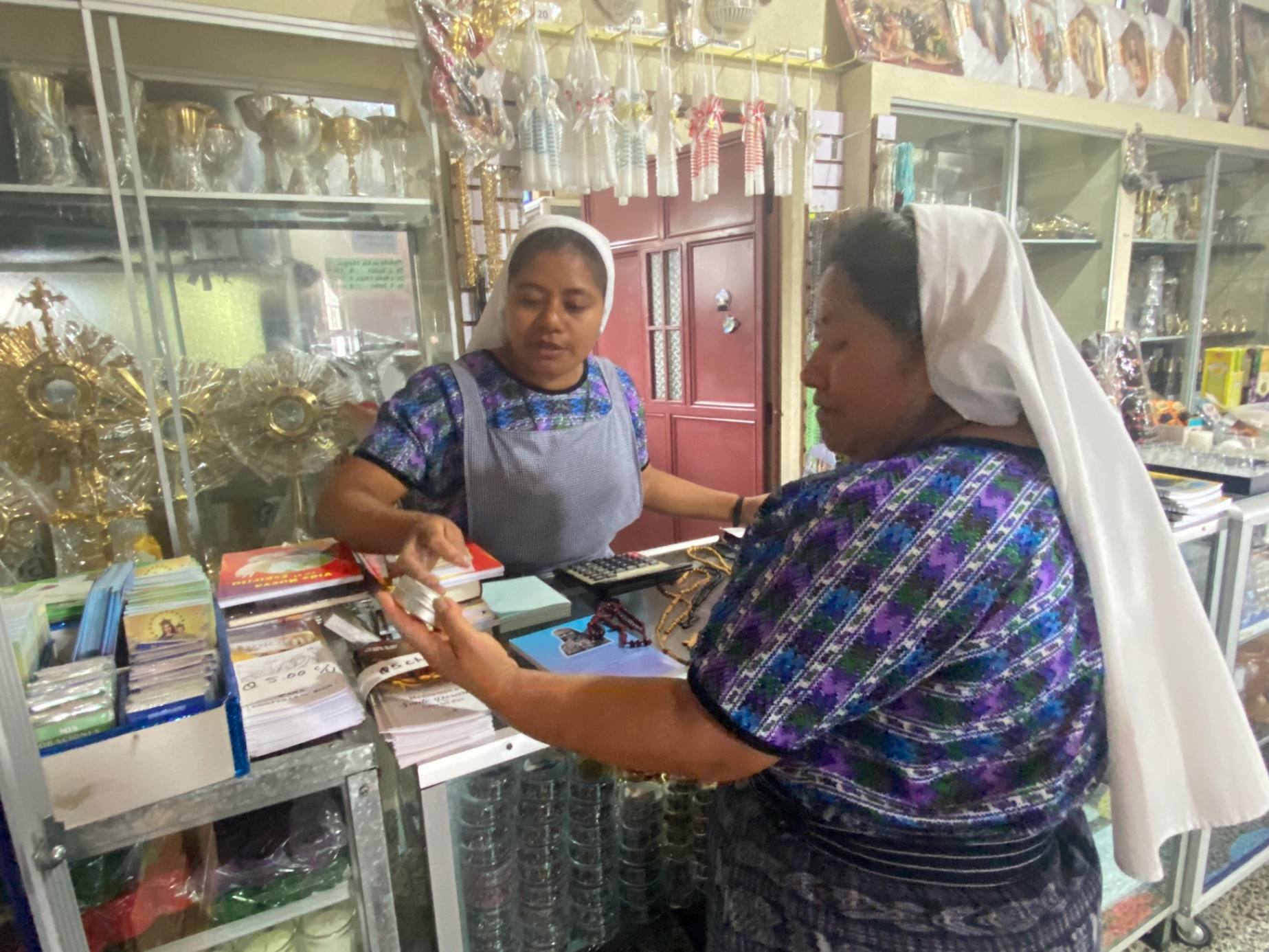 La Hna. Juana Toma Pérez le muestra una pomada de ingredientes naturales a la madre Marta Yach Cosme en la tienda de las Hermanas Misioneras de la Eucaristía en San Andrés Semetabaj, Guatemala, el 22 de agosto de 2023. (Foto: GSR/Rhina Guidos) 