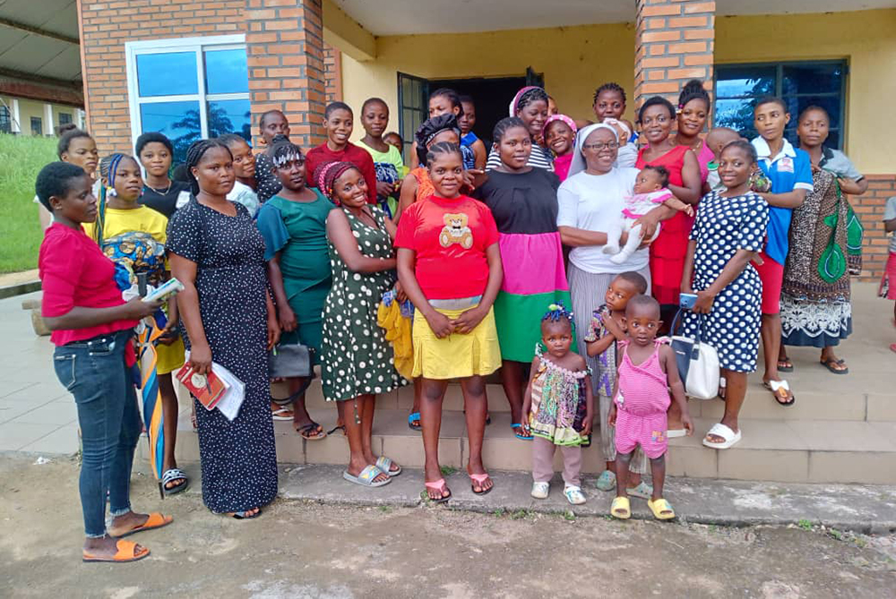 Sr. Rosemary Arrah holds a baby while posing for a picture with teenage mothers during one of the sessions at the Handmaids Education and Social Services Cameroon on Aug. 10, 2023. (Rosemary Arrah)