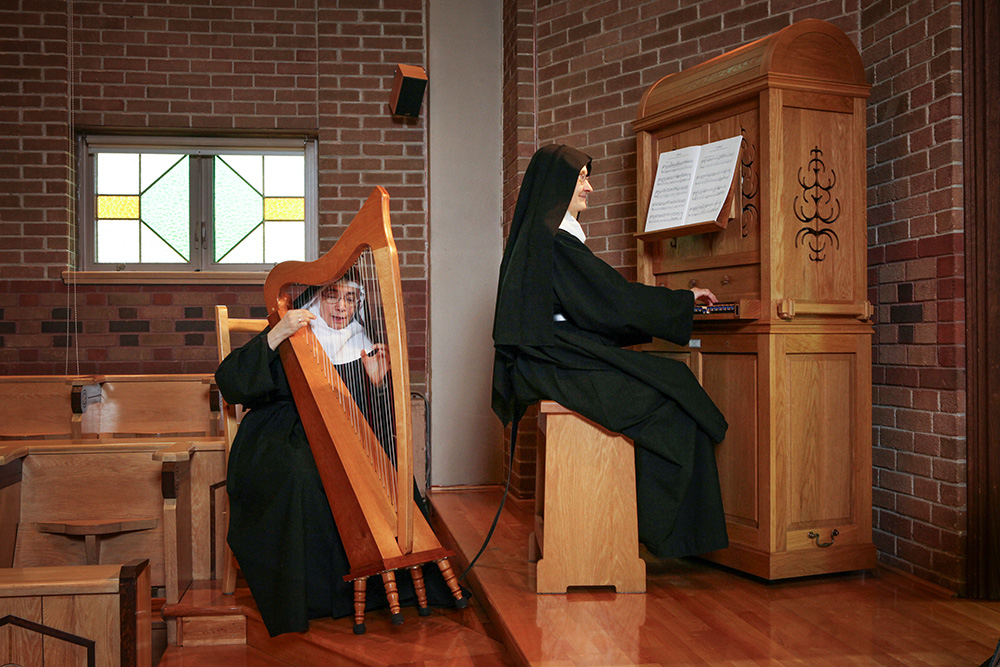 Benedictine Srs. Bernadette Roy, left, and Madeleine Saint-Aubin share their love of music as they engage in a duet at the Abbey of Sainte-Marie des Deux-Montagnes in Sainte-Marthe-sur-le-Lac, Quebec. (Courtesy of Serge Therrien)