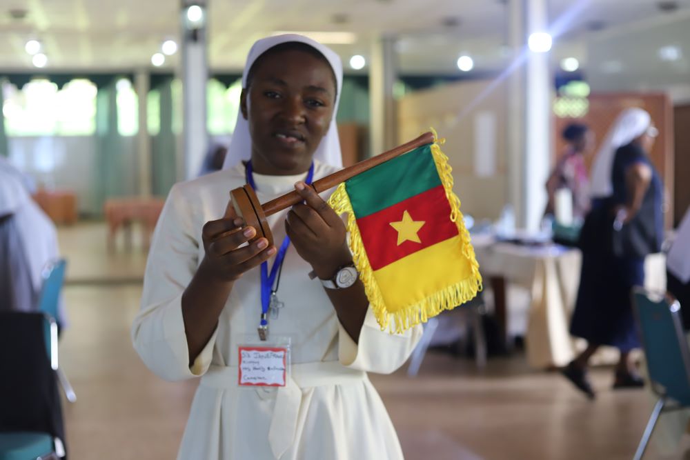 Sr. Janefrancis Kinyuy, a member of the Daughters of the Holy Family of Bafoussam, holds the flag of Cameroon during the All-Africa Conference: Sister to Sister convening in Entebbe, Uganda, April 10.