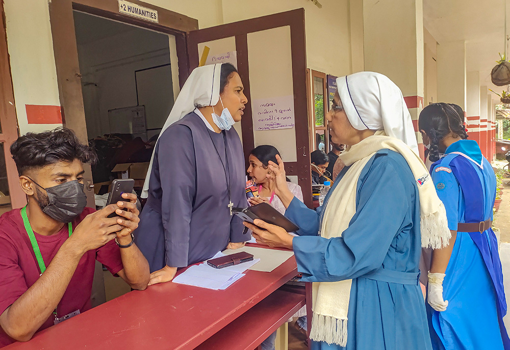 Maria Bambina Sr. Luxy James, right, in charge of the St. Joseph's School relief camp, briefs counselor Sr. Sherly Joseph on the current status of the camp residents. (Thomas Scaria)