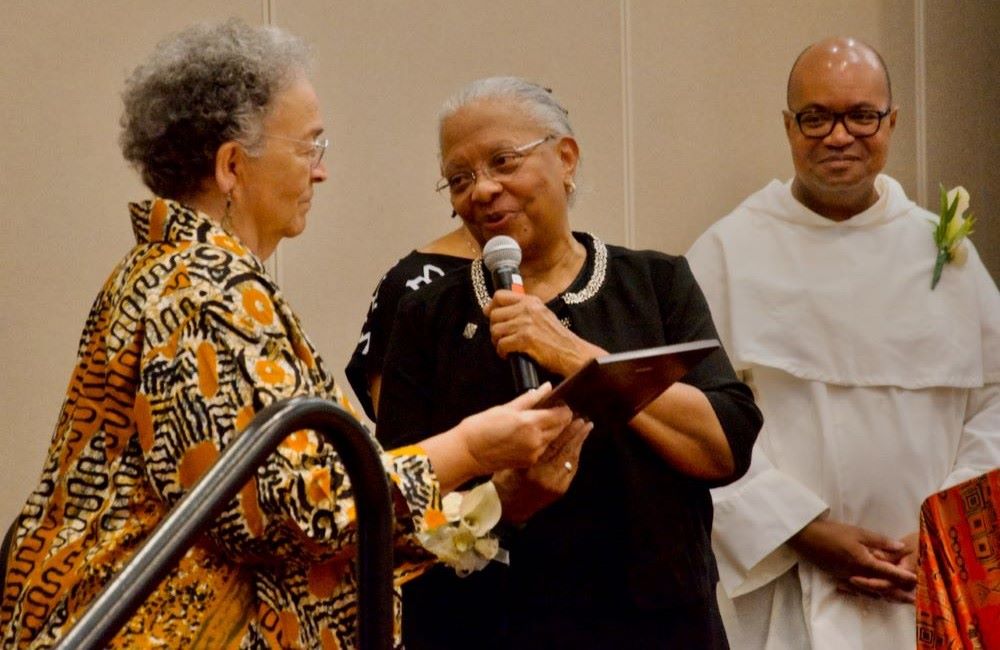 Sr. Eva Marie Lumas, a Sister of Social Service, (left) accepts the National Black Sisters Conference's Harriet Tubman Award from National Black Sisters' Conference President Sr. Addie Lorraine Walker July 29, 2024, in Louisville. Looking on is Fr. Jeffery Ott. (GSR photo/Dan Stockman)