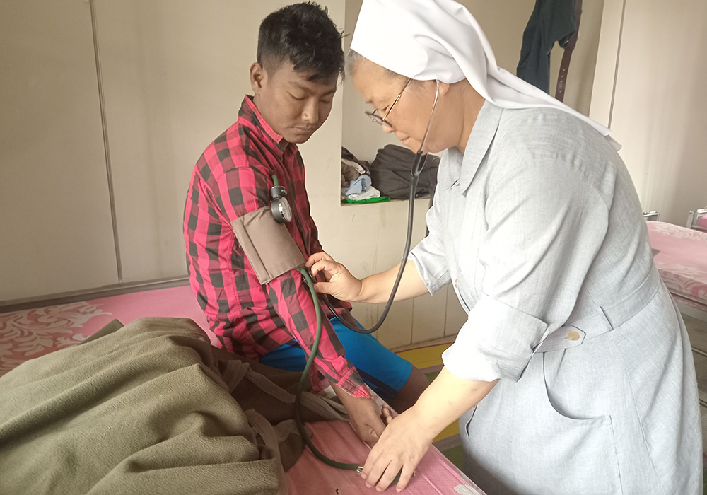 Korean national Sr. Maria Hyo Tjou Agnes of the Sisters of Charity of St. Vincent de Paul, a nurse, treats Sohaj Dajal, a 25-year-old patient at St. Vincent's Center & Clinic, Mymensingh, June 30. (GSR photo/Sumon Corraya)