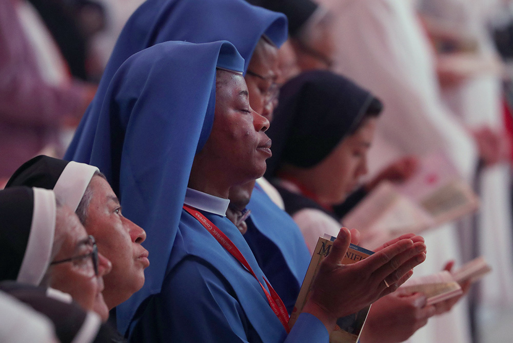 Religious sisters pray during Holy Qurbana July 20 at Lucas Oil Stadium in Indianapolis during the National Eucharistic Congress. Holy Qurbana is the name for Mass in the Catholic Church's Syro-Malabar rite. (OSV News/Bob Roller)