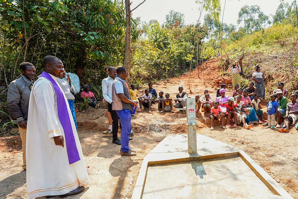 People of the Nthumbizira community in Konzalendo village in Malawi gather with parish priest Fr. Daniel Makwiti Sept. 12, 2022, for the opening ceremony and blessing of a newly installed water pump. (Courtesy of Monica Ichife)