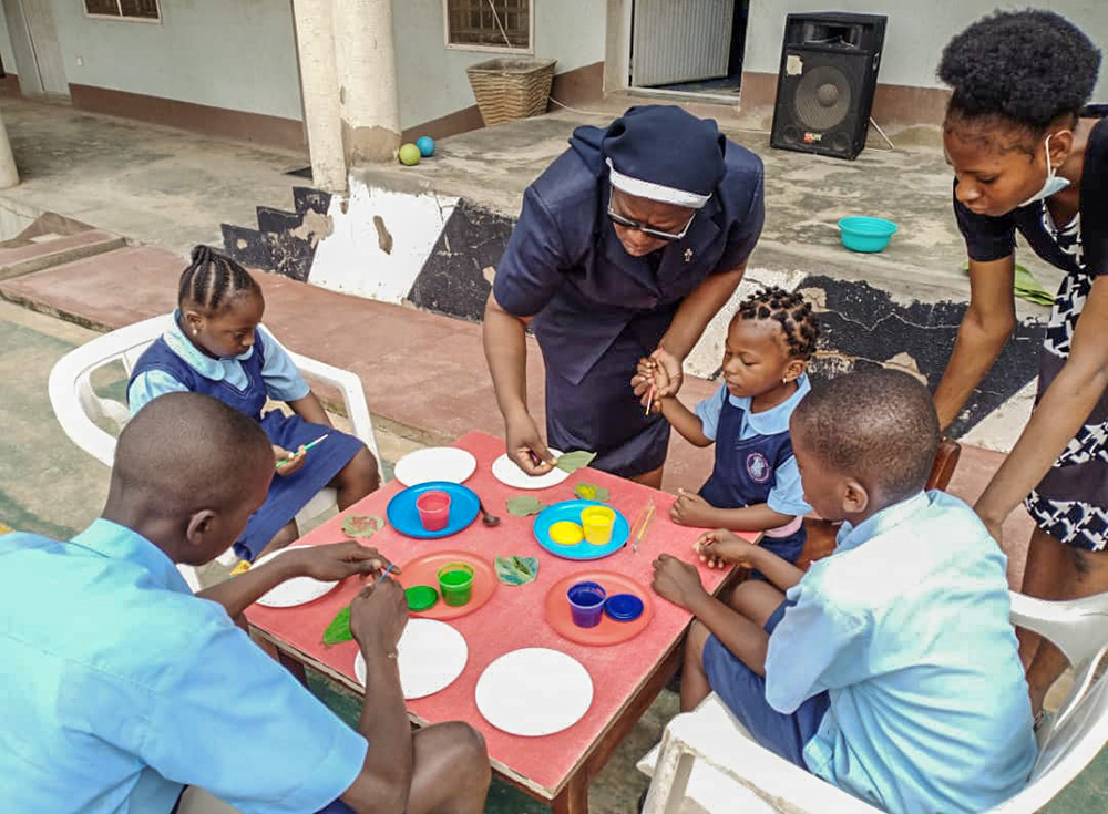 St. Louis Sr. Christie Udebor, center, supports students in a leaf painting activity at the Community Based Rehabilitation Center in Akure, Ondo state, Nigeria. (Courtesy of Christie Udebor)