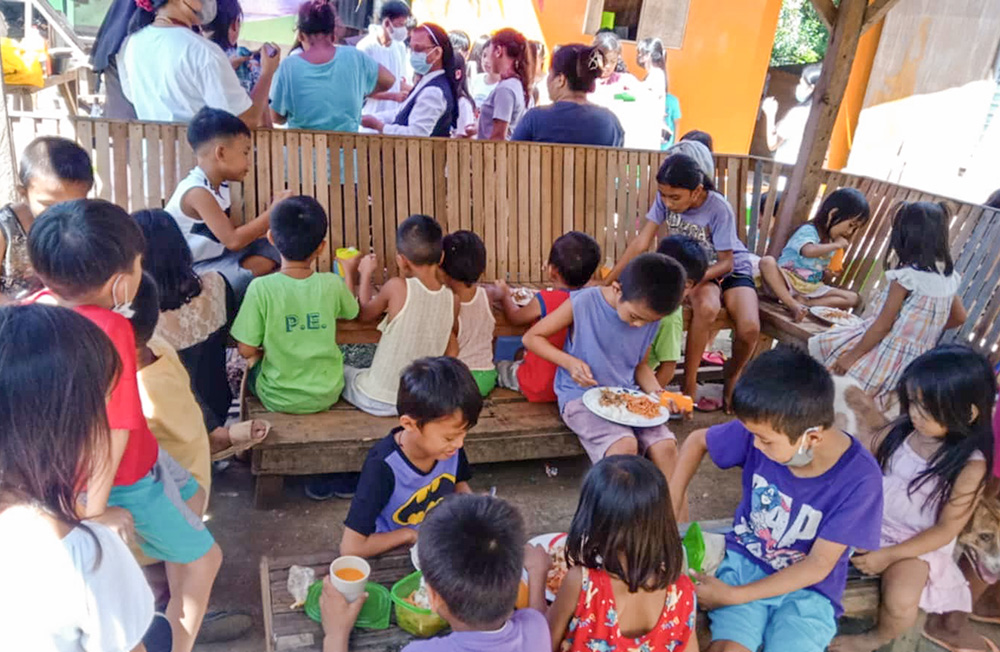 Children from the adopted community enjoy a meal in Lapu-Lapu City, Mactan Island, Cebu, Philippines. (Courtesy of Franciscan Sisters of the Immaculate Conception of the Holy Mother of God)