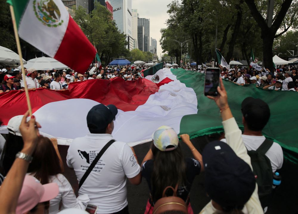 Manifestantes sostienen una bandera frente al edificio del Senado en Ciudad de México el 5 de septiembre, en señal de protesta contra la controvertida reforma del poder judicial del país, que da paso a una nueva era de elecciones para todos los jueces. La reforma aprobada fue impulsada por el presidente saliente. (Foto: Henry Romero/OSV News/Reuters)