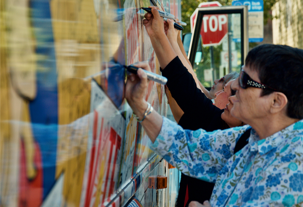 People sign the Nuns on the Bus motorcoach at the Circle Resource Center Oct. 8 in Chicago. (GSR photo/Dan Stockman)