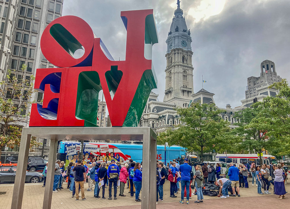 The crowd gathers between the bus and the Love sculpture in Philadelphia for the Sept. 30 rally to kick off the Nuns on the Bus and Friends tour. (GSR photo/Carol Zimmermann)