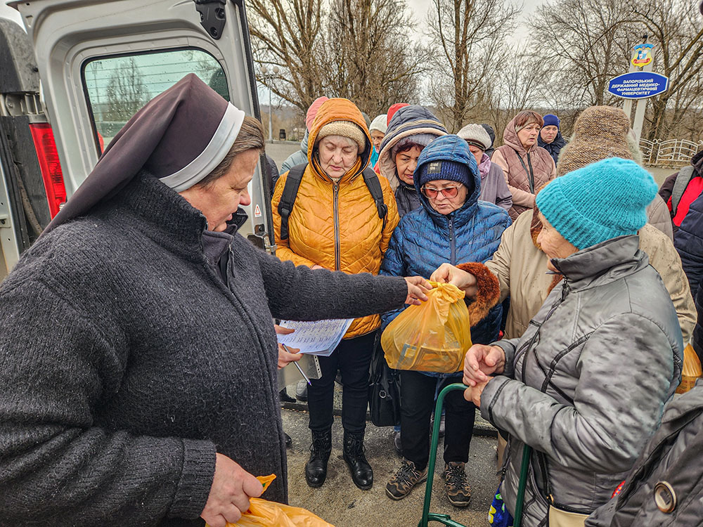 Basilian Sr. Lucia Murashko works during a distribution of donated backpacks, school supplies, hygiene items, blankets and other household supplies outside of a dormitory in Zaporizhzhia, Ukraine, that has been converted to residence for displaced persons. (GSR photo/Chris Herlinger)