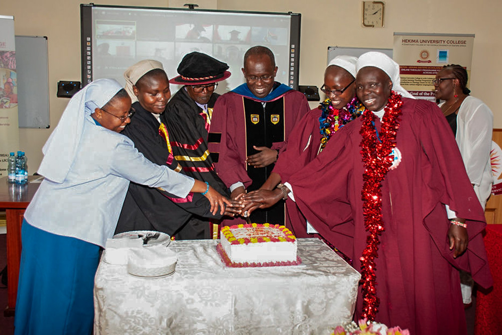 Emmanuel Sr. Gladys Ndege, left, helps cut the cake to celebrate the graduates of the 2023-24 cohort for the the Hilton-Hekima Sisters Scholars Program at Hekima University College in May 2024. (Courtesy of Religious Sisters Communicators' Foundation Uganda)