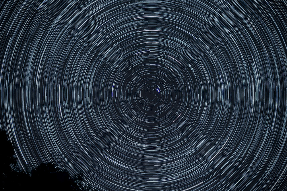 Time-lapse photograph of stars orbiting in a night sky (Unsplash/Patrick McManaman)