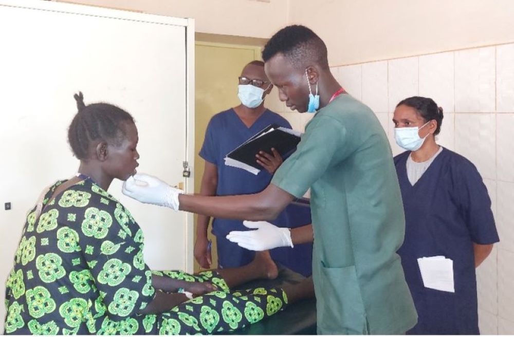 A nurse trainee takes a practical exam.