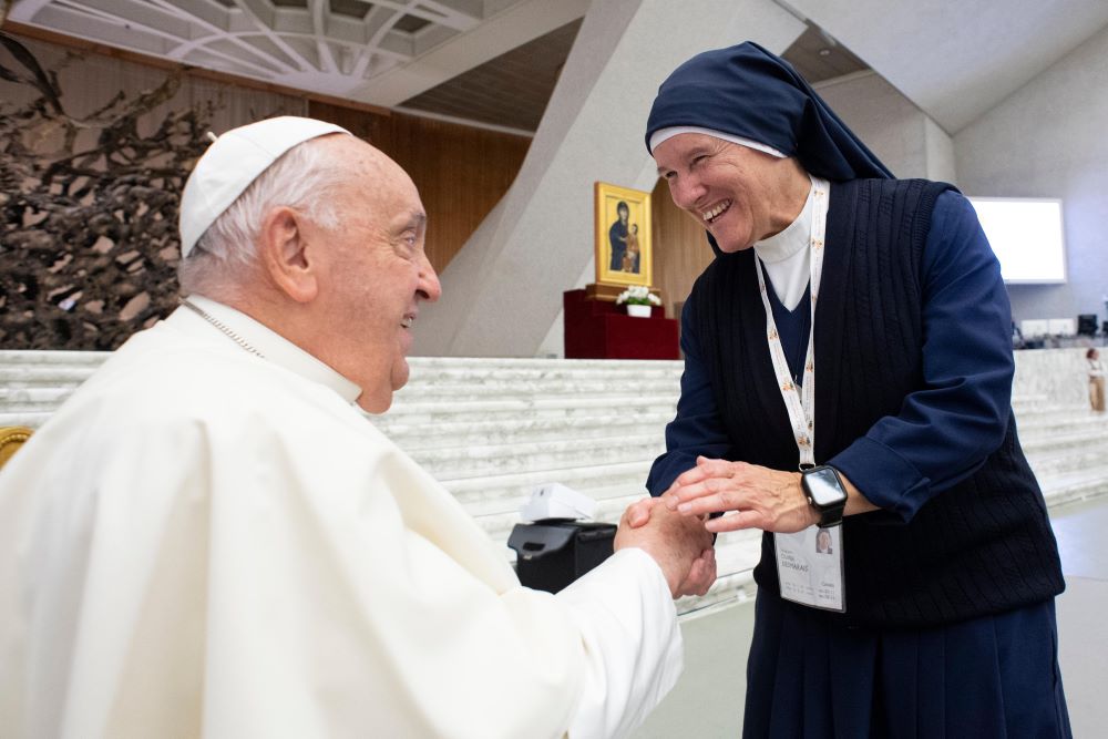 Pope Francis greets Sister Chantal Desmarais at a synod session.