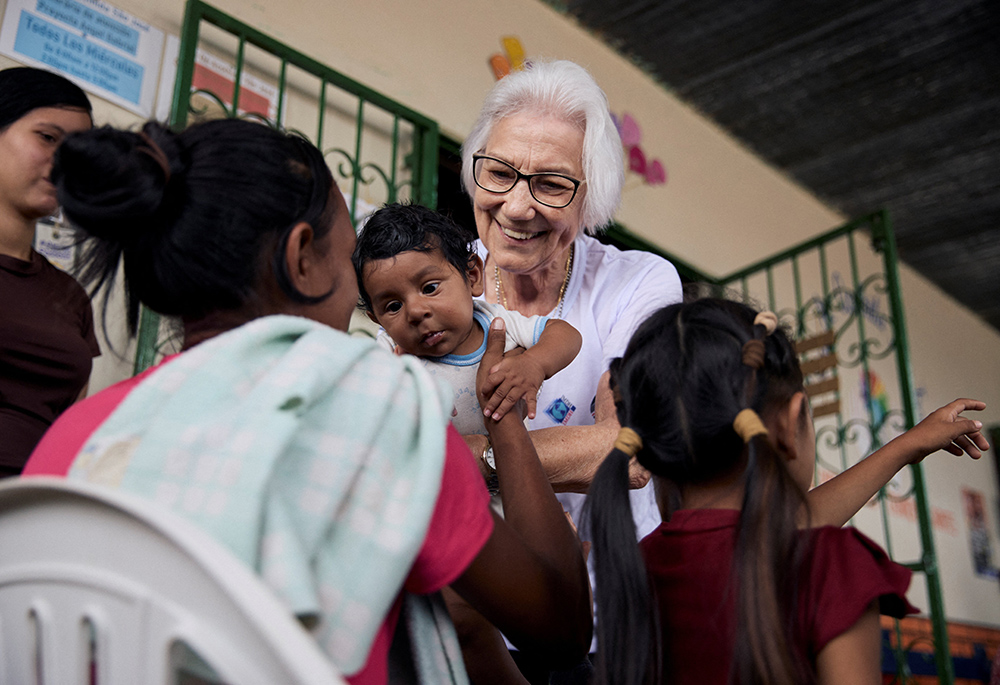 Scalabrinian Sr. Rosita Milesi, recipient of the 2024 Nansen Refugee Award from the Office of the United Nations High Commissioner for Refugees, holds baby Daniel Jose Milaro, who has just arrived from Venezuela with his mother Jenifer Milaro and siblings, at the Casa de Acolhida Sao Jose, a temporary shelter for refugees and migrants in Pacaraima, Brazil, on Aug. 24. (UNHCR/Marina Calderon/Handout via Reuters)