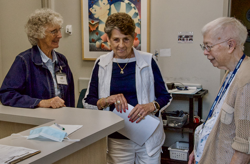 From left: Sr. Kathleen Neely, executive director Ellen Wells, and Sr. Martha Staarman speak at the Family Community Clinic in Louisville, Kentucky, where the sisters volunteer as translators. (GSR photo/Dan Stockman)