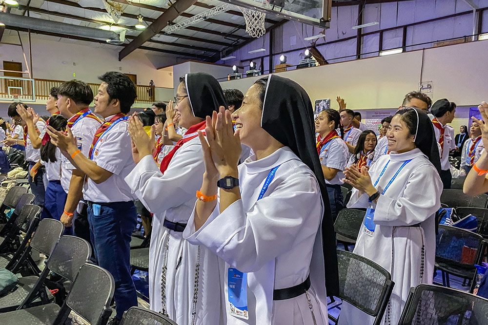 Sisters Mary Augustine, Paulina Thérèse and Rose Martin, Dominican Sisters of Mary Immaculate Province, participate in the convention's theme song and dance before a keynote talk. (Catherine Teresa Bui)