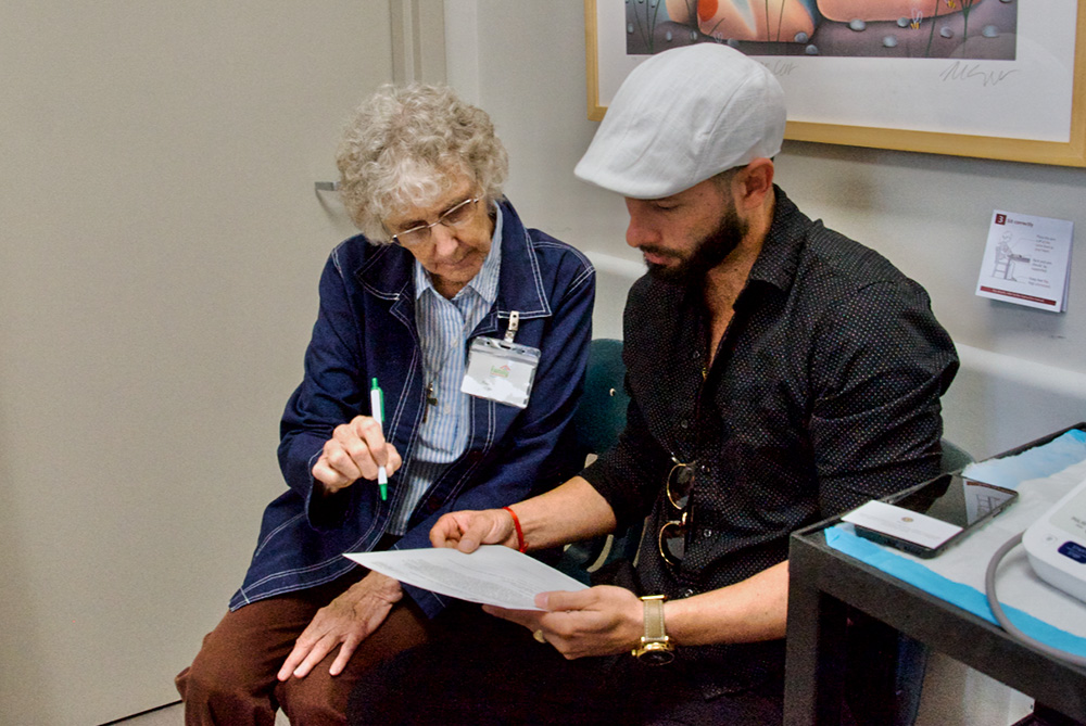 Sr. Kathleen Neely speaks in Spanish to a patient at the Family Community Clinic in Louisville, Kentucky, where she volunteers as a translator. (GSR photo/Dan Stockman)