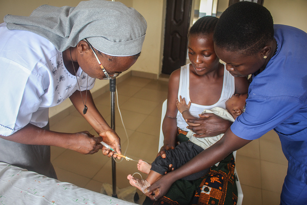 Medical Missionaries of Mary Sr. Helen Omeya, acting matron at the Mary Martin Primary Health Center in Torugbene, Nigeria, administers a treatment for dysentery to a 5-month-old baby. (GSR photo/Valentine Benjamin)