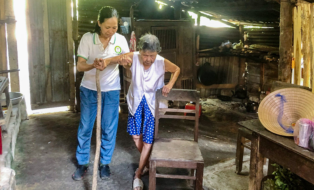 Maria Huynh Thi Kim Yen, member of the Daughters of Our Lady of the Visitation Association, cares for Le Thi Nga at her house on Aug. 11. (Joachim Pham)